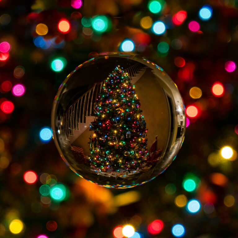 Capture the magic of Christmas with a colorful tree reflected in a shiny ornament.