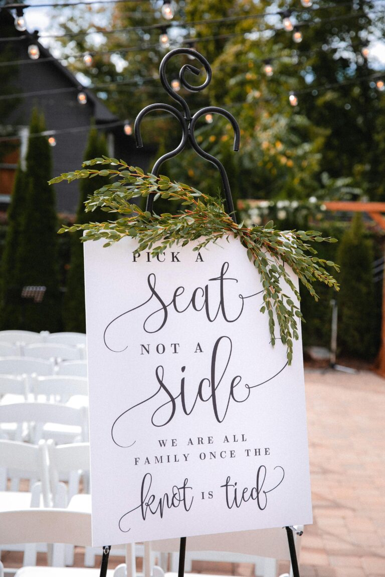 Charming wedding sign outdoors urging guests to 'Pick a Seat Not a Side'.